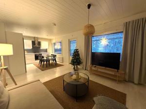 a living room with a television and a christmas tree at Arctic Circle Holiday Homes in Rovaniemi