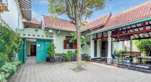 ein Haus mit einem Baum im Innenhof in der Unterkunft Capital O 93938 Wisma Pamungkas Syariah in Ngemplak