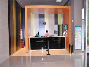 two people sitting at a counter in a lobby at Jinjiang Inn Luoyang Nanchang Road Wangfujing in Luoyang