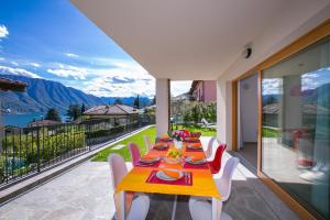 a dining room with a table and chairs on a balcony at Villa Inti in Tremezzo