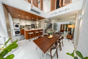 eine Küche und ein Wohnzimmer mit einem Holztisch und Stühlen in der Unterkunft Terasek Terrace with Private Pool in Kuala Lumpur