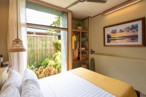 a bedroom with a bed and a large window at Tadhana Villa in General Luna +4 photos