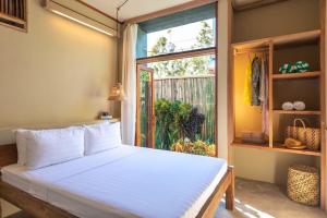 a bedroom with a white bed and a window at Tadhana Villa in General Luna