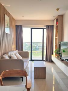 un salon avec un canapé et une télévision dans l'établissement Châu Giang Nera Garden Apartment- Căn hộ 3 phòng ngủ view đẹp FREE Hồ bơi, Gym, à Thôn Văn Dương