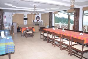 a restaurant with tables and chairs in a room at Dragon I Resorts in McLeod Ganj