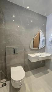 a bathroom with a toilet and a sink and a mirror at Central Residence by Paramount Hospitality in Karachi +15 photos