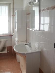 ein weißes Badezimmer mit einem Waschbecken und einem Spiegel in der Unterkunft Villa Mafi in Nus