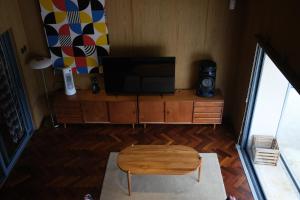 a living room with a tv and a wooden cabinet at Villa Cannary in Tegalharendong