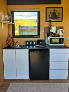 a small kitchen with a microwave and a sink at Perrys South by Tiny Away in Forth +39 photos