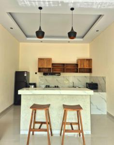 une cuisine avec deux tabourets et un comptoir dans l'établissement Ubud Serenity Villa, à Mantaak