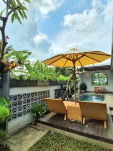 une terrasse avec un parasol et une piscine dans l'établissement Ubud Serenity Villa, à Mantaak