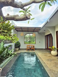 une piscine au milieu d'une maison avec un arbre dans l'établissement Ubud Serenity Villa, à Mantaak