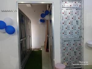 a corridor with a door with blue balloons at AC Comfort Guest House in Deoghar