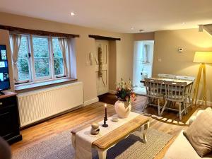 ein Wohnzimmer mit Tisch und ein Esszimmer in der Unterkunft Charming Grade 2 Cottage w/ Garden in Warminster in Warminster