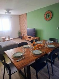 una mesa de comedor con platos y copas de vino en Tara, en Saint-Pierre