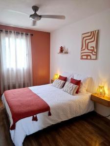 Un dormitorio con una cama grande con una manta roja. en Tara, en Saint-Pierre