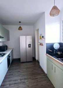 cocina con nevera blanca y suelo de madera en Tara, en Saint-Pierre