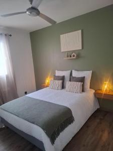 Un dormitorio con una gran cama blanca con dos lámparas. en Tara, en Saint-Pierre