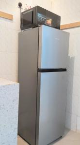 a microwave sitting on top of a refrigerator at Madonna 1BR Apartment with Fast WiFi and Pool in Morogoro +3 photos