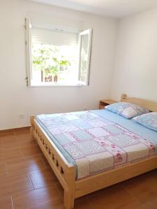 ein Schlafzimmer mit einem Bett in einem Zimmer mit einem Fenster in der Unterkunft Apartments Rogoznica in Rogoznica