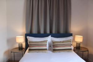 ein Schlafzimmer mit einem weißen Bett mit zwei Lampen in der Unterkunft SixtyNine Beach Cottage in Torreira