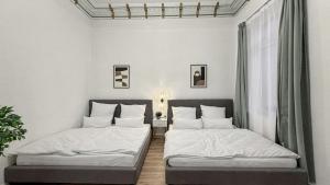 twee bedden in een kamer met witte muren bij Denkmal-Apartment zentral in Krefeld mit hohen Decken in Krefeld