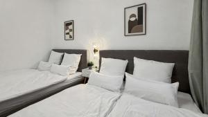 2 bedden in een kamer met witte lakens en kussens bij Denkmal-Apartment zentral in Krefeld mit hohen Decken in Krefeld