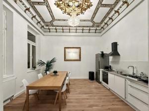 een eetkamer met een tafel en een kroonluchter bij Denkmal-Apartment zentral in Krefeld mit hohen Decken in Krefeld