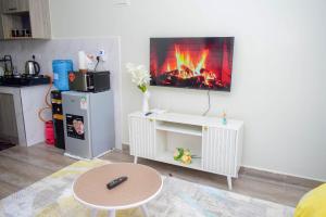a living room with a fireplace on the wall at Stayride Homes in Ruaka
