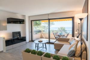 a living room with a couch and a table at SeaHomes Vacations - Cala Banys Seafront Apt & PKG in Lloret de Mar