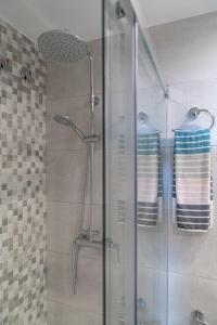 a shower with two towels on a glass door at SeaHomes Vacations - Cala Banys Seafront Apt & PKG in Lloret de Mar +17 photos