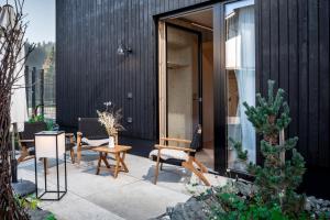 Un patio con sillas y mesas frente a un edificio. en Langerwegh Apartments AP1, en Fieberbrunn