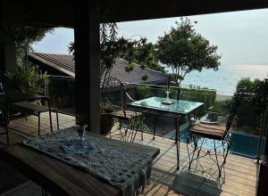 a patio with a table and chairs and a view of the ocean at Eliseos Bed & Kitchen in San Juan