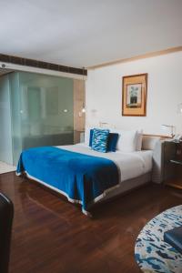 um quarto com uma cama grande com um cobertor azul em The Park New Delhi em Nova Deli