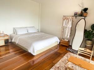 Ban Huai KhaiGobgab Station room 2的卧室里有一张白色的床和一面镜子