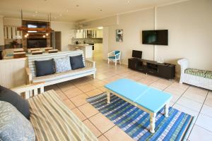 ein Wohnzimmer mit Sofa und Fernseher in der Unterkunft Noa Haven, Langebaan, 4 Sleeper in Langebaan