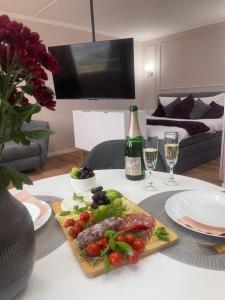 a table with a plate of food and a bottle of wine at See- & Bergblick Oberteuringen 58 mit beheiztem Indoor-Pool in Oberteuringen