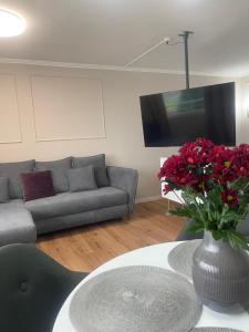 a living room with a couch and a vase of flowers at See- & Bergblick Oberteuringen 58 mit beheiztem Indoor-Pool in Oberteuringen +22 photos