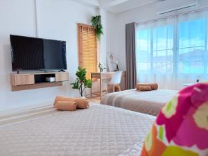 une chambre avec deux lits et une télévision à écran plat dans l'établissement Na KlongMuang I ณ คลองเมือง, à Phra Nakhon Si Ayutthaya