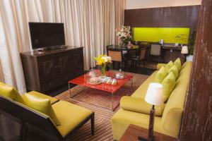a living room with a yellow couch and a television at The Park New Delhi in New Delhi