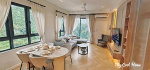 a living room with a couch and a table with chairs at Onsen Suite Theme Park View in Ipoh