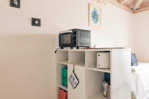 Un pequeño estante blanco con un microondas encima. en Cà Armonia 1 Lake & Mountain View Apartment, en Mergoscia 52 fotos más