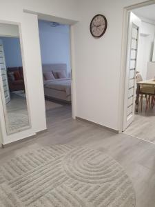 a living room with a couch and a clock on the wall at Gaby's Apartment in Ocna-Mureşului
