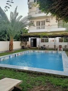 ein großes Schwimmbad vor einem Gebäude in der Unterkunft Set ma'at in Luxor