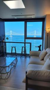 a living room with a couch and a view of a bridge at Charman Ocean View Sunrise 10 seconds to the beach in Kwangan-dong