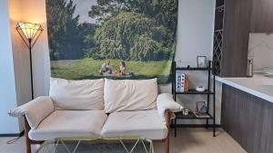 a living room with a couch and a painting on the wall at Charman Ocean View Sunrise 10 seconds to the beach in Kwangan-dong