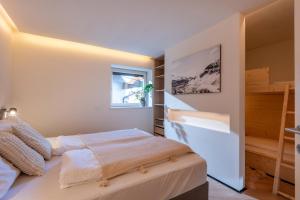 Un dormitorio pequeño con una cama y una ventana. en Langerwegh Apartments AP2, en Fieberbrunn