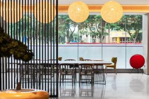 ein Esszimmer mit Tischen und Stühlen und großen Fenstern in der Unterkunft JI Hotel Guangzhou Sports Center Tianhe North Road in Guangzhou