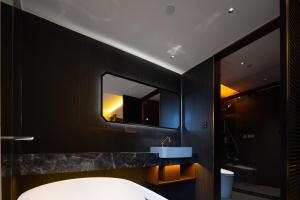 成都市にあるThe Panda Artisan, Taikoo Li Xilia Hotelの洗面台と鏡のあるバスルーム