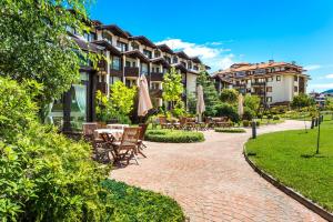 班斯科Warm Evenings in Perun lodge的配有桌椅和遮阳伞的露台